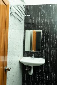 La salle de bains est pourvue d'un lavabo et d'un miroir. dans l'établissement Aruna Residency, à Sankarankovil