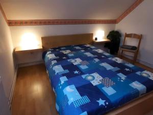 1 dormitorio con 1 cama con edredón azul en Holiday apartment Stern in the heart of the Harz, en Wildemann