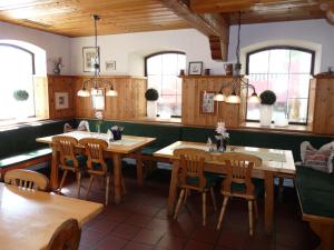 a restaurant with wooden tables and chairs and windows at Rottaler Stuben in Bad Birnbach