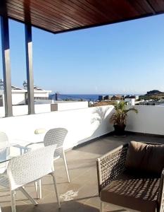un patio con sillas y un sofá y vistas al océano en 3bed villa with private pool and rooftop with a sea view in flic-en-flac, Mauritius en Flic-en-Flac