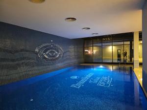 basen z niebieskimi światłami w budynku w obiekcie PERFECT RESİDENCE TAKSİM, 2 BEDROOM, POOL, Gym, Sauna w Stambule