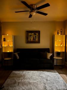 a living room with a black couch and a ceiling fan at Little France in Phillipsburg