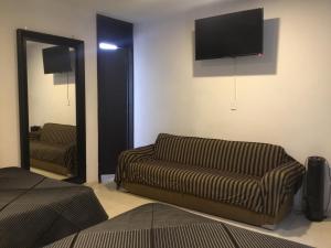 uma sala de estar com um sofá e uma televisão de ecrã plano em Hotel Tao em Atlixco