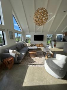 un salon avec un canapé et une télévision dans l'établissement Paradise by Simpsons beach, à Whitianga