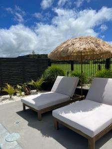 - 2 lits et un parasol sur la terrasse dans l'établissement Paradise by Simpsons beach, à Whitianga