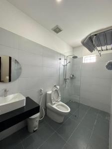 Baño blanco con aseo y lavamanos en THIÊN NGA HOTEL, en Buôn Alê (1)