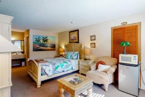 um quarto com uma cama, uma cadeira e uma mesa em Miami Suite 102 - Tradewinds em Eureka Springs
