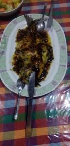 un plato de comida en una mesa con un tenedor y un cuchillo en purple villa, en Mirissa