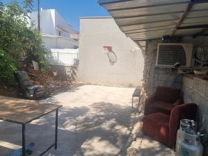 a patio with a couch and a basketball hoop on a wall at בית על חצי דונם במרכז קרית שמונה in Qiryat Shemona