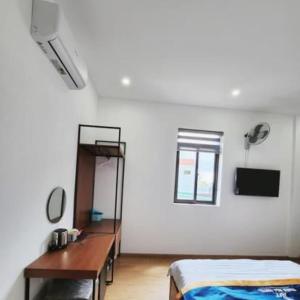 1 dormitorio con 1 cama y escritorio en una habitación en THIÊN NGA HOTEL, en Buôn Alê (1)