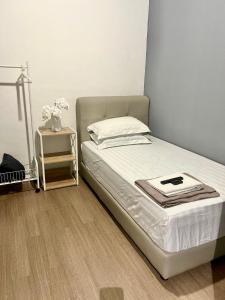 ein Schlafzimmer mit einem Bett und einem Nachttisch in der Unterkunft Theresa's Homestay in Tawau