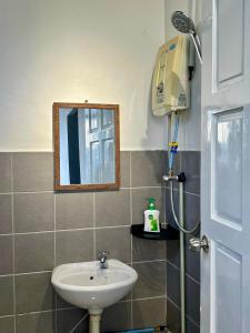 uma casa de banho com um lavatório e um espelho em Theresa's Homestay em Tawau