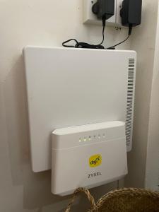 a white computer with a air conditioner next to a wall at Theresa's Homestay in Tawau +2 photos