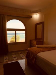 a bedroom with a large window and a bed at Calma Mocha House in Dahab