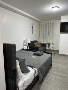 1 dormitorio con 1 cama grande y 1 sofá en Condo in Ortigas, en Manila