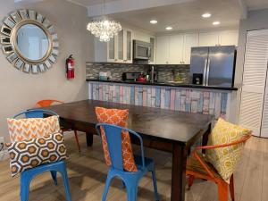 a kitchen with a wooden table and blue chairs at MAGICAL Xcape, POOLS-SPA, WALK 2 DISNEY, CENTRAL AC-HEAT, FULLY EQUIPPED, 2 FREE PARKING SPACES, OWNER MGMT in Anaheim