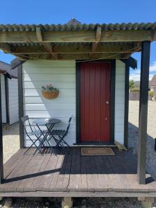 een huis met een rode deur en een tafel op een terras bij Wedderburn Farm Stay in Wedderburn