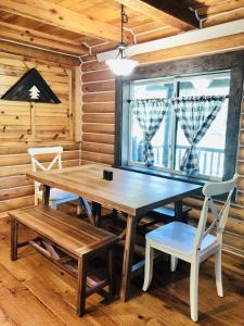 uma mesa de madeira e cadeiras num quarto com uma janela em 20 Mins To Ynp-cabin-pet Friendly em Island Park