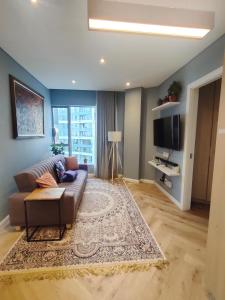 een woonkamer met een bank en een televisie bij Modern 1BR APT Near Sandton City No Loadshedding in Johannesburg