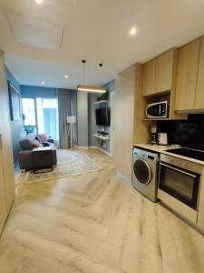 uma sala de estar com uma cozinha com placa de fogão e forno em Modern 1BR APT Near Sandton City No Loadshedding em Joanesburgo