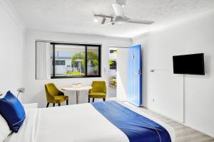 a bedroom with a bed and a table with chairs at Montego Mermaid Beach Motel in Gold Coast