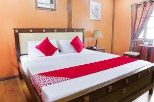 a bedroom with a large bed with red pillows at LaVeranda Beach Resort in Dauis