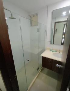 een badkamer met een glazen douche en een wastafel bij Cartagena Beach Apartment - Salida Directa Al Mar in Cartagena