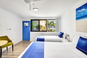 una camera d'albergo con due letti e un tavolo di Montego Mermaid Beach Motel a Gold Coast