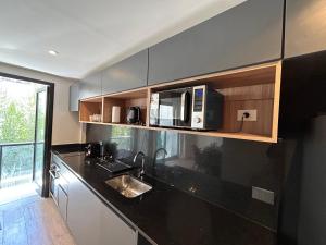 a kitchen with a sink and a microwave at Live Soho Boutique & Apartments Palermo Hollywood in Buenos Aires