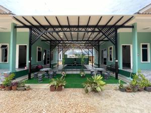 een patio met tafels en stoelen in een gebouw bij Teratak Sakinah Guest House in Tambun