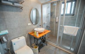 a bathroom with a toilet and a sink and a shower at Na Jie 17 in Donghe