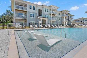 een zwembad met ligstoelen voor een gebouw bij 2 Bedroom Apartment near NAS Jax Base in Jacksonville