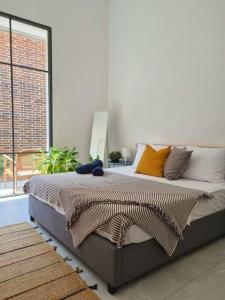 a large bed in a room with a large window at Modern Brickhouse in Bandung