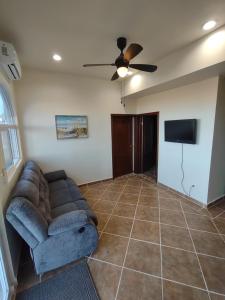 a living room with a couch and a flat screen tv at *3BR/2 KING Suites/3.5 BATH Rooftop w/Ocean Views in Puerto Peñasco