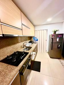 a kitchen with a stove and a refrigerator at Apartamento completo in Ibagué
