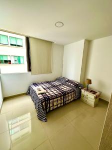 a small bedroom with a bed and a window at Apartamento completo in Ibagué