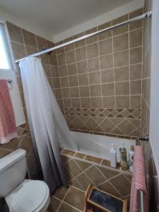 a bathroom with a shower curtain and a toilet at *3BR/2 KING Suites/3.5 BATH Rooftop w/Ocean Views in Puerto Peñasco