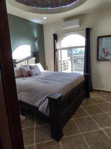 um quarto com uma cama grande e uma janela grande em *3BR/2 KING Suites/3.5 BATH Rooftop w/Ocean Views em Puerto Peñasco