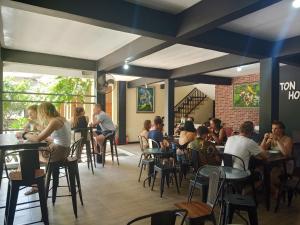 a group of people sitting at tables in a restaurant at New Eston House in Banyuwangi