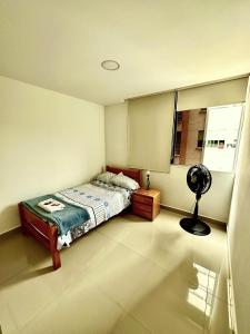 a bedroom with a bed and a fan in it at Apartamento completo in Ibagué