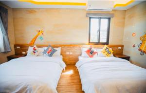 2 camas en una habitación con una jirafa en la pared en Na Jie 17 en Donghe