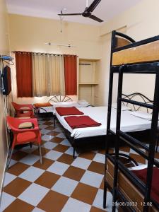 a bedroom with two bunk beds and a chair at Shanthi Comforts in Dāvangere