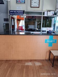 a counter in a restaurant with a clock on the wall at Shanthi Comforts in Dāvangere
