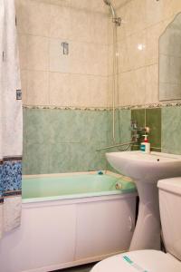 een badkamer met een wastafel, een bad en een toilet bij Эдем in Petropavlovsk