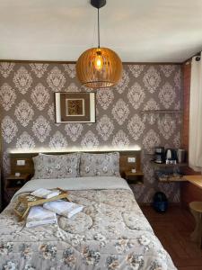 a bedroom with a bed and a chandelier at Hospedagem Souza in Urubici