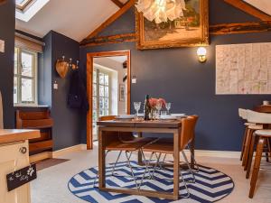 comedor con mesa de madera y sillas en The Stables en Waltham on the Wolds