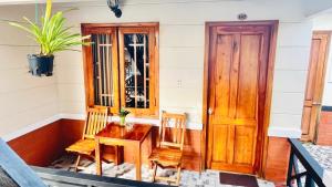weranda ze stołem, 2 krzesłami i drzwiami w obiekcie Nhat Huy Bungalow Phu Quoc w Duong Dong