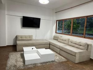 a living room with a couch and a flat screen tv at Villas regazó de paz, ven a buscar tu paz en la naturaleza in Concepción de La Vega