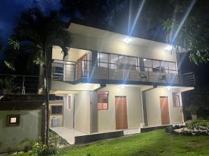 a large white house with a balcony at night at Villas regazó de paz, ven a buscar tu paz en la naturaleza in Concepción de La Vega
