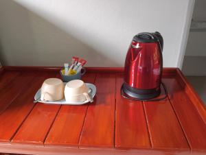 a red coffee maker and two cups on a table at Tropical Paradise Leelawadee Resort in Ko Chang